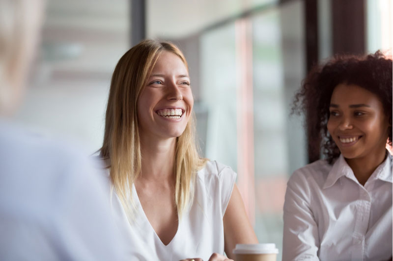Two women laughing in a meeting