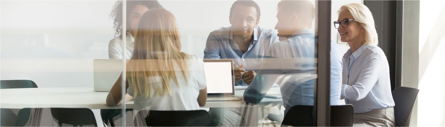 Group of people sitting in a large glass office