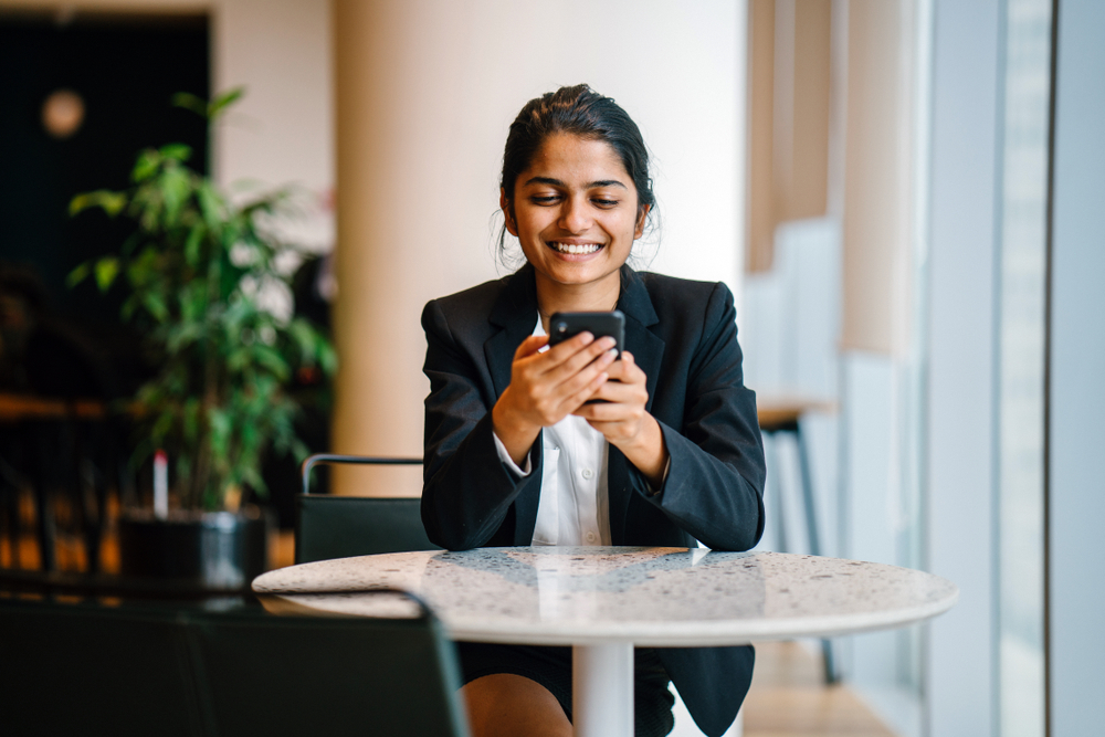 Happy Female Professional Looking at Smartphone