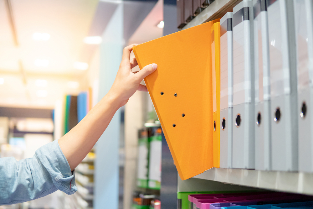 Hand placing bookstore supplies on shelf